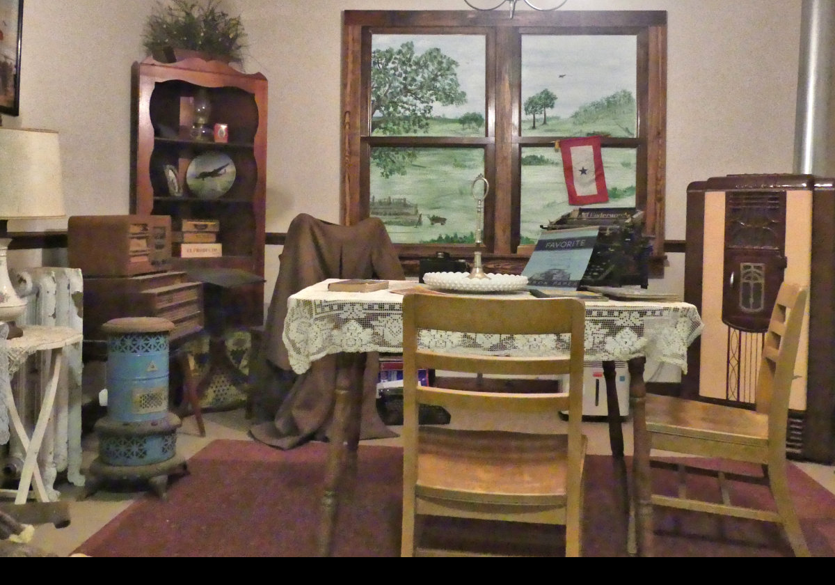 Another view of the dining room. This time, note the indoor paraffin heater lower left. As a child, I remember my father using these to heat his greenhouse through the winter.  Not sure the fumes did the plants much good.