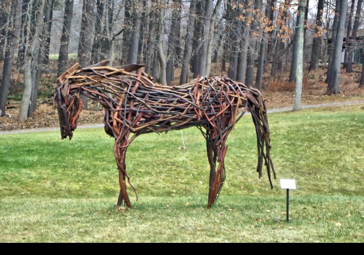 Outside the museum, there is a horse sculpture titled "Tres Bien". It was made from driftwood in 2014 by Rita Dee.